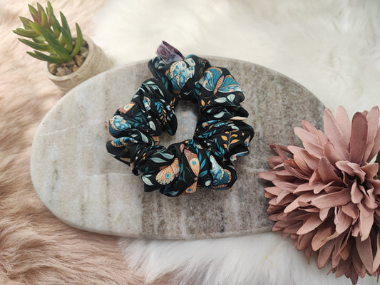 Mittlere Midnight Moth Scrunchie von Yvoshandcraftworld aus Stoff mit Schmetterlingsmuster auf einem weißen Hintergrund